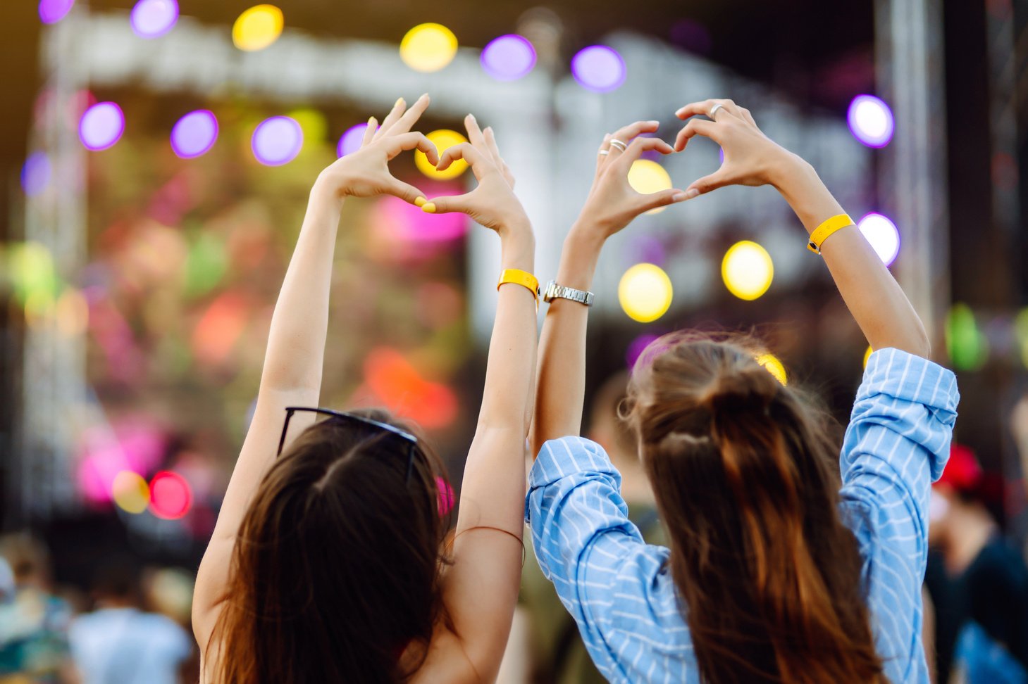 Heart shaped hands at concert. Music concert with lights and silhouette of people enjoying concert.